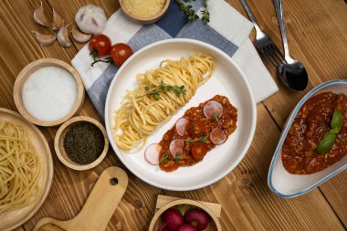 Lezzetli yiyecekler, ev yapımı spagetti, kıymalı domates sosu ve fesleğen fırlatma elementleri, şef masası dekoratif baharatlarla servis ediliyor. Varsayım.