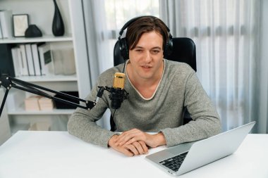 Sunucu kanalı, gülümseyen akıllı yayıncı kaydı, senaryosu ve akıllı telefonuyla sosyal medyada sohbet programı, kulaklık takarak modern ev stüdyosundaki video flamalarını kaydediyor. Bireysel.