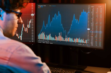 Piyasa stoku grafik veritabanında Neon Modern Ofis 'te yan manzaralı gerçek zamanlı ekranlarda çalışan genç bir tüccar. Dinamik finansal döviz kuru kavramı. Toplayıcı.