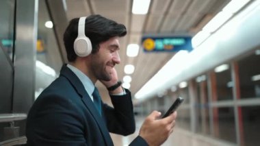 Tren istasyonunda geçmişi bulanık bir şekilde beklerken kulaklıkla müzik dinleyen zeki bir iş adamı. Yetenekli proje yöneticisi cep telefonu tutarken dinlenme sesi dinlemeyi sever. Sevinçli..