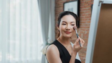 Kadın nüfuzlu kişi canlı yayın yapan video görüntülerini sosyal medya ya da blog üzerinden gözden geçiriyor. Kozmetik stüdyosu ışıklandırmalı mutlu genç kız çevrimiçi pazarlama oturumu yayını için..