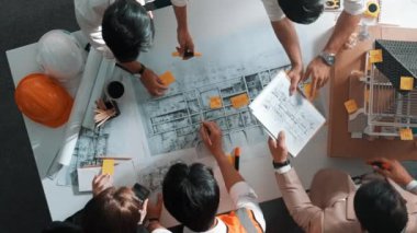 Becerikli mühendis ekibinin ev inşaatından bahsedişinin en alt görüntüsü. Mimar ya da tasarımcı grubunun planlar hakkında beyin fırtınası yapmak için tartışan ve yazan hava görüşü. Hizalama.