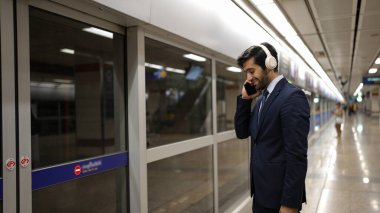 Akıllı bir iş adamı tren istasyonunda kulaklık takarken telefon eder. Profesyonel yönetici, tren ya da metro beklerken pazarlama stratejisi hakkında meslektaşıyla konuşuyor. Sevinçli..