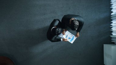 Proje yöneticisi mali belge verirken Lider 'in telefonu aramasının en üst görüntüsü. Yatırımcıyla konuşan bir iş adamı veri analizine bakarken telefonla fikir alışverişinde bulunuyor. Zaman aşımı. Müdürlük.