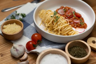 Lezzetli yiyecekler, ev yapımı spagetti, kıymalı domates sosu ve fesleğen fırlatma elementleri, şef masası dekoratif baharatlarla servis ediliyor. Varsayım.