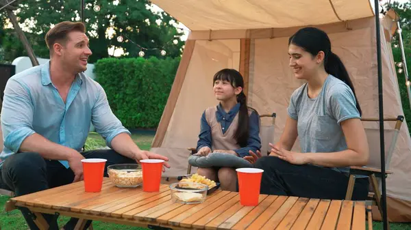 stock image Family all together sit at camp in garden with tasty snack. Lovely parent use outdoor camping activity as way to communicate and spending time with young generation cross generation gap. Divergence.