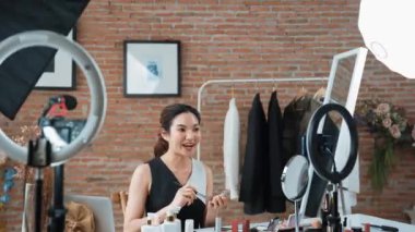 Kadın nüfuzlu kişi canlı yayın yapan video görüntülerini sosyal medya ya da blog üzerinden gözden geçiriyor. Kozmetik stüdyosu ışıklandırmalı mutlu genç kız çevrimiçi pazarlama oturumu yayını için..