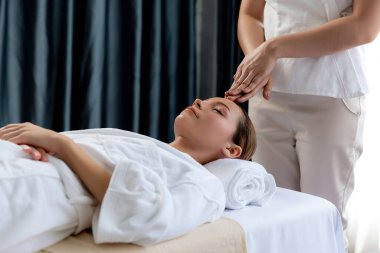 Kafkasyalı kadın stres önleyici kafa masajından ve lüks tatil beldesi ya da otel spa salonundaki modern ışık ortamında yüz güzelliği eğlencelerini şımartmaktan hoşlanıyor. Sessiz.