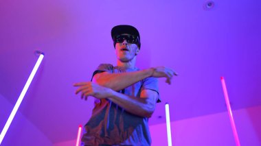 Beyaz dansçının gösterişli gözlükler taktığı ve break dans yaptığı alçak açılı kamera. Çekici adam kendinden emin bir şekilde kameraya bakarken enerjik bir performans ve hareket gösterdi. Mutluluk.