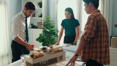 Akıllı mimar ya da inşaat mühendisi bina yapısı fikrini not edip plana yapıştırıyor. Yöneticinin çeşitli meslektaşları ve ev planlarıyla birlikte çalıştığı hava görüşü. Hizalama.