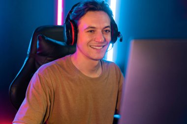 Kazanmak için çevrimiçi oyun oynayan akıllı flama makinesinin sunucu kanalı, neon ışıklı odada seçilen takım yarışması için izleyicilerle birlikte canlı yayında canlı yayında kulaklık takıyor. Bireysel.