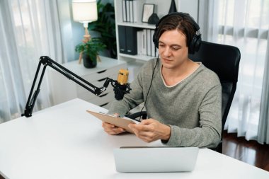 Akıllı yayıncının sunucu kanalı canlı sosyal medya yayını ile dinleyicilere senaryo okuyarak, kulaklık takarak modern ev stüdyosundaki video flamalarını kaydediyor. Bireysel.