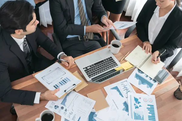 Ofis masasındaki finansal veri raporlarını analiz eden çeşitli bir grup iş analisti. Stratejik pazarlama planlaması için iş istihbarat analizine göre grafikler ve grafikler.