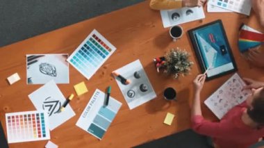 Renk paletinden renk seçmek için birlikte çalışan zeki iş adamlarının zaman aşımı. İşadamı logo grafiğine bakarken pazarlama ekibine tablet kullanarak yönetici fikri sundu. Sempozyum.