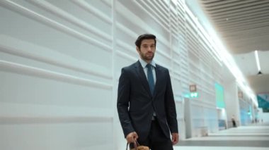 Beyaz arka planda dururken kameraya bakan bir iş adamı. İş elbisesi giyerken kameraya gülümseyen başarılı adamın yakın çekimi. Yönetici, kameraya bak. Hareket eden kamera. Sevinçli..