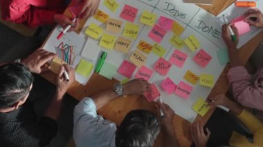 Renkli yapışkan notlarda pazarlama ve planlama stratejisi yazarken insanların yazma ve çalışma tahtası oluşturma konusunda üst düzey bir bakış açısı. Akıllı takım Kanaban tahtasını kullanarak iş performansını yönetir. Cemaat.