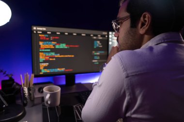 İki pc ekranda veri yazılım geliştirme analizi yapan akıllı bilişim geliştiricisi, neon ışıklı siber ofiste güncellenmiş uygulama programı güncellenmiş online web sayfası sistemi yaratıyor. Tahmin et..