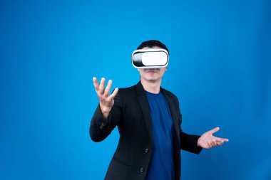 Finansal rapora bağlı VR gözlük takan işadamı mavi arka planı izole ederek, gelecekteki veri analizi iletişim teknolojisi sanal gerçeklik kopyalama uzayını açıklıyor. Entrika.