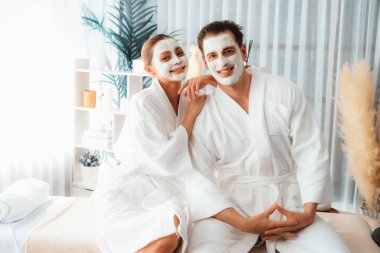 Yüzü kremli, bornozlu mutlu bir çift tatil boyunca kaplıca salonu ya da otelin huzurlu atmosferinin tadını çıkarıyor. Şımarık yüz spa 'sı ve cilt bakımı, esans rahatlığı. Sessiz.