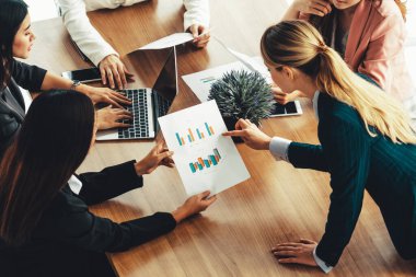 Modern işyeri ofisindeki diğer iş kadınlarıyla grup toplantısındaki iş kadını masada dizüstü bilgisayar ve belgelerle konuşuyor. Kurumsal iş dünyası konsepti. uds