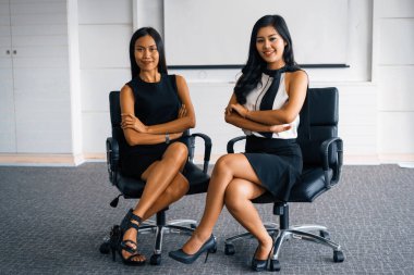 Ofiste oturan iki genç Asyalı iş kadını. İş arkadaşları ve toplum konsepti. uds