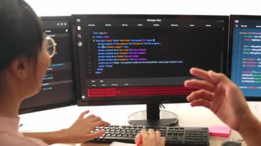 Yavaş çekim arkası yazılım geliştirici mühendisi bilgisayar programlama için birlikte çalışarak hata ayıklama kodunu çözüyor, ofiste monitörde karmaşık algoritmaları çözüyor. Filizlenen