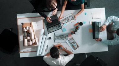 Mimarlık ekibi iç mimariye tasarımı tartışıyor, işaret ediyor ve sunuyor. Havadan görüşlü profesyonel iş adamları ev modeliyle birlikte binanın içini araştırıyorlar. Hizalama.