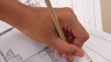 Ölçüm aracı ve kalem el kullanan akıllı mimar veya akıllı mühendisin videosu mimari ofisteki inşaat hatasızlığı için ayrıntılı bir tasarım hazırladı. Eline odaklan. - Yakın çekim. Tanımlama.