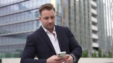 Becerikli iş adamı, çatıda dikilirken takımla sohbet etmek için telefonu kullanıyor. Pazarlama ekibiyle iletişim kurarken gökdelen görüşüyle telefonda çalışan proje yöneticisinin ön görüntüsü. Urbane.