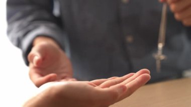Yavaş çekimde kutsal haçı diğerine teslim etmek Katolik inancı dönüşümünün bir göstergesidir. Hristiyan takipçi diğerini dönüştürüyor. Aşkın ve fedakârlığın sembolü olarak haç ve İncil 'i veriyor. Filizlenen