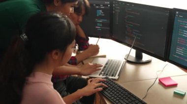 Yavaş çekim arkası yazılım geliştirici mühendisi bilgisayar programlama için birlikte çalışarak hata ayıklama kodunu çözüyor, ofiste monitörde karmaşık algoritmaları çözüyor. Filizlenen