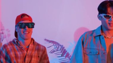 Break dansçı takımının modern stüdyoda pembe ışıkla dans etmesini kapatın. Çok kültürlü insanlar moda kıyafetleri giyerek hip hop müziğine geçiyorlar. Çılgın, komik bir ruh hali. Mutluluk.