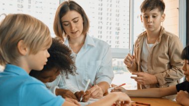 Masada masal kitabı ve renkli kitapla otururken çeşitli öğrencilere hikaye anlatan profesyonel beyaz bir öğretmen. Eğitmenden renkli resim alırken akıllı öğrenci dinlemeyi öğrenir. Etkinlik.