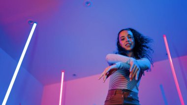 Latin dansçıların kameraya bakıp şehrin pop müziğiyle dans ettiği düşük açılı kamera. Profesyonel çekici hipster, mor veya neon ışıklı hip hop şarkısına geçiyor. Şık bir kumaş. Mutluluk.