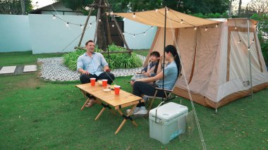 Family all together sit at camp in garden with tasty snack. Lovely parent use outdoor camping activity as way to communicate and spending time with young generation cross generation gap. Divergence. clipart