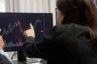 Dinamik borsada döviz kuru yatırımını tartışan iki ticaret simsarı iki bilgisayar ekranında gerçek zamanlı risk grafiği ya da modern ofisteki kar noktasını karşılaştırıyor. Varsayım.