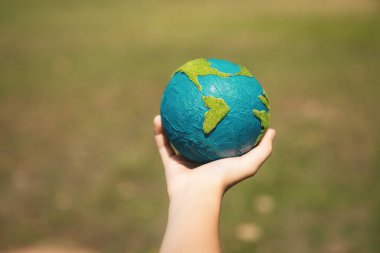 Dünya gezegenini ESG ilkesi ve çevre dostu enerjisiyle daha parlak bir gelecek için Dünya günü olarak el ele tutuşan genç çocuklar. Döngü