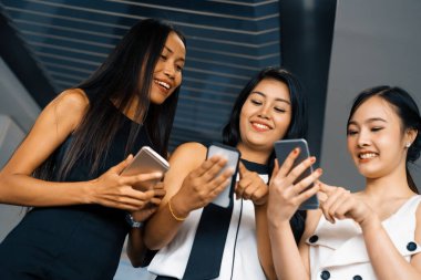 Üç kadın arkadaş ellerinde cep telefonuyla sohbet ediyorlar. Sosyal medya, dedikodu haberleri ve online alışveriş kavramı. uds