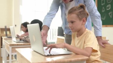 Çeşitli öğrenciler yapay zeka yazılımı kullanırken, Kafkas öğretmeni enerjik çocuğa kodlama konusunda yardım ediyor. Çocuklar oturma ve programlama sistemi. Sevimli bir öğrenci şifreyi öğreniyor. Pedagoji.