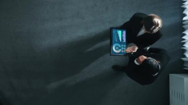 Yetenekli iş adamının yukarıdan görünüşü bir ekibe katıldı ve yönetici müdürle tokalaştı. Pazarlama ekibinin tabletteki yatırım verilerini analiz etmek için birlikte çalışması zaman aşımı. Müdürlük.