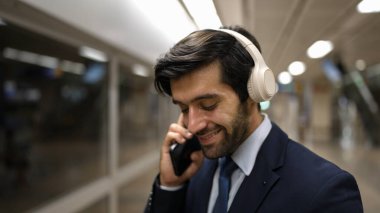 Akıllı bir iş adamı tren istasyonunda kulaklık takarken telefon eder. Profesyonel yönetici, tren ya da metro beklerken pazarlama stratejisi hakkında meslektaşıyla konuşuyor. Sevinçli..