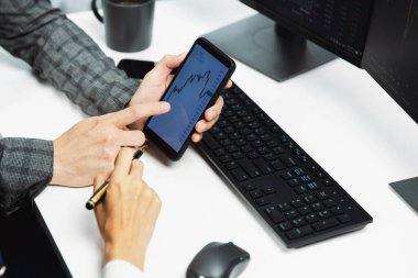 İşadamı olarak kalemle işaretlenmiş, kadın yatırımcının internet sitesi program uygulamasının akıllı telefonuyla kontrol ediliyor. İç işlerindeki dinamik borsa ile kontrol ediliyor. İnfobahn.