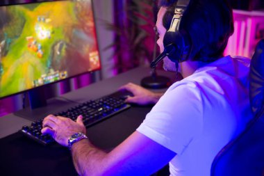 Moba çevrimiçi oyununa odaklanan akıllı akım oyunculu kulaklıklar takarak bilgisayar ekranında mupti ya da neon dijital siber ışık odasındaki savaş alanında yetenekli bir takım ile birlikte. Tahmin et..