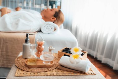 Aromaterapi masajı gündüz atmosferinde ya da spa salonunda bulanık bir kadına odak dekor ve spa aksesuarları kurarak tatil köyünde ya da otel arka planında keyifli aroma spa masajı yapan bir masaj. Sessiz.