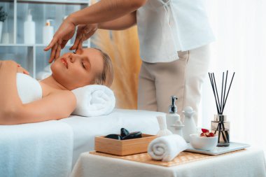 Kafkasyalı kadın stres önleyici kafa masajından ve lüks tatil beldesi ya da otel spa salonundaki modern ışık ortamında yüz güzelliği eğlencelerini şımartmaktan hoşlanıyor. Sessiz.