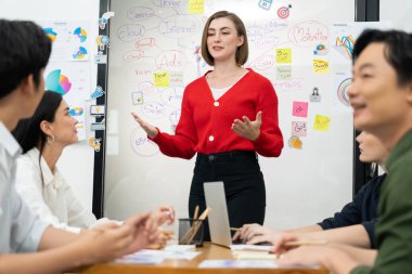 Profesyonel çekici kadın lider, modern iş toplantı odasında beyin fırtınası zihin haritalama istatistikleri ve renkli yapışkan notlar kullanarak yaratıcı pazarlama planını sunuyor. Tertemiz..