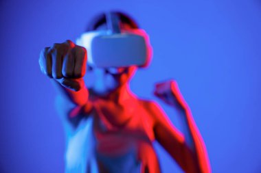 VR kulaklık takan zeki bir kadın metaevrene bağlanıyor, gelecekteki siber uzay topluluğu teknolojisi. Duruş kontrol oyuncusunu yumruklayan zarif bir kadın dövüş oyunları oynuyor. Halüsinasyon.