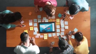 Yazılımcının web tasarımı hakkında beyin fırtınası yapması ve planlaması tablet kablo prototipine bakarken zaman aşımı. Yetenekli müteahhit takımının dijital uygulamadan bahseden hava görüşü. Sempozyum.