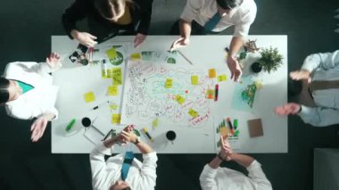 İş adamlarının zihin haritasını kullanarak beyin fırtınası yapmak için birlikte çalıştıklarına dair üst düzey bir görüş. Akıllı yöneticinin el ele tutuşmasını ya da el ele tutuşmasını gösteren hava görüntüsü. Hizalama.