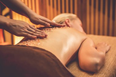 Lüks spa salonlarında sıcak mum ışığında cilt bakımı yaptıran kadın müşteri. Sağlık Spa vücut fırçasında tuz temizleme güzellik tedavisi. Sessiz.